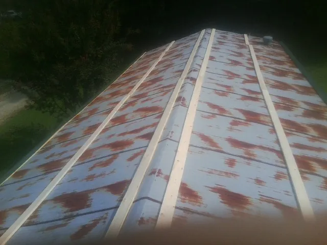 Rusted metal roof panels with new wood purlins before replacement — Storm Damage Roof Repair in Maynardville by Roofing Brothers
