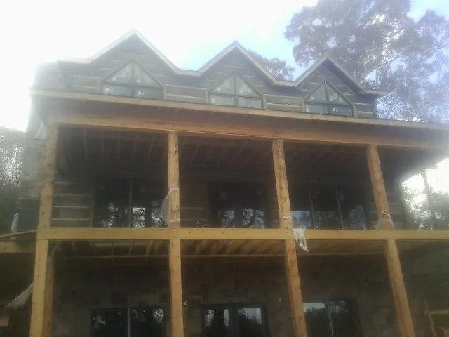 Dormers and porch framing on a large log home under construction — Roof Coating work by our crew in Maynardville