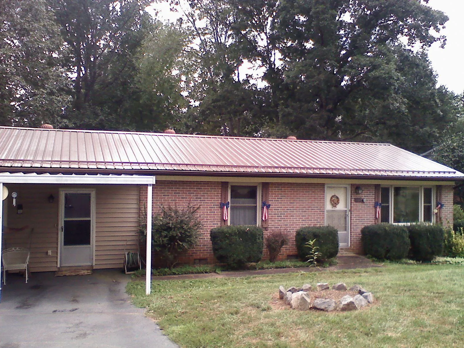 Bronze metal roof and carport on a brick ranch home — Roof Repair work by our crew in Maynardville